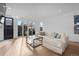 Bright living room with sliding glass doors, light wood flooring, and a modern glass coffee table at 3646 Quivas St, Denver, CO 80211