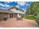 Backyard patio area with dining table, grassy yard and home's rear elevation under a partly cloudy sky at 3150 Lane Ct, Boulder, CO 80305
