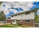 Rear elevation of a two-story home featuring a brick foundation and white siding at 3150 Lane Ct, Boulder, CO 80305
