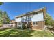Rear elevation of a two-story home with a brick foundation, white siding and a grassy backyard at 3150 Lane Ct, Boulder, CO 80305