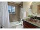 Bathroom features a shower-tub combo, granite vanity and a window with nice exterior views at 30221 Marge Ln, Evergreen, CO 80439