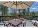 Outdoor deck with umbrella, views of the surrounding forest, and seating for six or more at 30221 Marge Ln, Evergreen, CO 80439