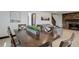 Inviting dining area with wood table adjacent to the living room and a stone fireplace at 30221 Marge Ln, Evergreen, CO 80439