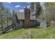 Charming exterior view of home with brick chimney, nestled amongst towering pine trees and lush greenery at 30221 Marge Ln, Evergreen, CO 80439