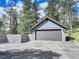 A detached garage is constructed with horizontal siding with an asphalt driveway and fencing at 30221 Marge Ln, Evergreen, CO 80439