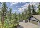 Spacious two-car garage and fenced parking area providing ample parking and storage, surrounded by trees at 30221 Marge Ln, Evergreen, CO 80439