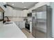 Bright kitchen featuring stainless steel appliances, white cabinetry, and elegant countertops at 30221 Marge Ln, Evergreen, CO 80439