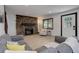 Bright living room featuring stone fireplace, hardwood floors, and comfortable grey sofas with yellow pillows at 30221 Marge Ln, Evergreen, CO 80439