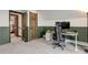 The office is situated with a desk and computer; features wood door and white and green trim at 30221 Marge Ln, Evergreen, CO 80439