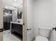 Modern bathroom featuring a sleek vanity, glass-enclosed shower, and black herringbone tile at 900 S Webster St, Lakewood, CO 80226