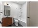 Well-lit bathroom with a modern vanity, toilet, and bathtub with shower head at 900 S Webster St, Lakewood, CO 80226