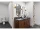 Bathroom showcasing a double vanity with modern fixtures, decorative sconces, and a toilet at 900 S Webster St, Lakewood, CO 80226