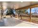 Spacious covered patio with wood support posts and tile flooring offering a backyard view at 900 S Webster St, Lakewood, CO 80226