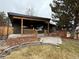 Modern home with a dark brick exterior, covered patio, and stone pathway, blending contemporary style with natural elements at 900 S Webster St, Lakewood, CO 80226