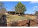 Landscaped front yard with a modern house, mature tree, decorative rock feature, and well-maintained lawn at 900 S Webster St, Lakewood, CO 80226