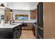 Bright kitchen featuring an island, modern appliances, wood floors, and a window with a view at 900 S Webster St, Lakewood, CO 80226