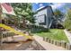 Spacious backyard features a fun slide and sandbox area with mature trees and a well-maintained lawn at 11760 Eudora Ct, Thornton, CO 80233