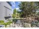Beautifully landscaped backyard with stone pathway, lush greenery, and mature trees creating a serene outdoor space at 11760 Eudora Ct, Thornton, CO 80233