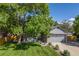 Attractive home with a lush green lawn, mature tree, and charming front porch at 11760 Eudora Ct, Thornton, CO 80233