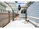 Cozy backyard patio with pergola and snow-covered stone flooring at 2028 Ulster St, Denver, CO 80238