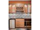 Close up of a stylish bar area featuring granite countertop, sleek cabinetry, and convenient mini fridge at 2028 Ulster St, Denver, CO 80238