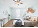 Stylish bedroom with pale blue walls, wood floors, queen bed, and decorative wall hangings at 2028 Ulster St, Denver, CO 80238