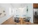 Open dining area with a glass table, sleek chairs, and views of the kitchen at 2028 Ulster St, Denver, CO 80238