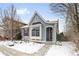 Charming craftsman style home with red door and snow covered walkway at 2028 Ulster St, Denver, CO 80238