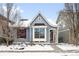 Charming home with blue siding, a bay window, red shutters, and a snow-covered yard at 2028 Ulster St, Denver, CO 80238