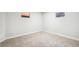 Spacious basement with neutral carpet, two small windows and freshly painted white walls at 12807 Garfield Cir, Thornton, CO 80241