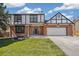 Lovely Tudor-style home with brick exterior, black trim and an attached two car garage on a sunny day at 12807 Garfield Cir, Thornton, CO 80241