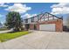 Charming Tudor-style home featuring a brick facade, attached garage, and a well-maintained front lawn at 12807 Garfield Cir, Thornton, CO 80241
