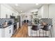 Modern kitchen featuring white cabinetry, black countertops, and stainless steel appliances at 12807 Garfield Cir, Thornton, CO 80241