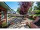 Spacious backyard with gravel area, mature tree, and brick retaining wall at 3792 E Briarwood Ave, Centennial, CO 80122