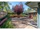 Spacious backyard with gravel area, mature tree, and fire pit at 3792 E Briarwood Ave, Centennial, CO 80122