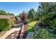 Landscaped backyard with tiered levels, stone accents, and mature trees at 3792 E Briarwood Ave, Centennial, CO 80122