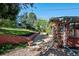 Landscaped backyard with brick retaining wall, mature trees, and a patio area at 3792 E Briarwood Ave, Centennial, CO 80122