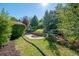 Landscaped backyard with grassy area, mature trees, and brick retaining wall at 3792 E Briarwood Ave, Centennial, CO 80122