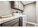 Basement laundry room with washer, dryer, and cabinets at 3792 E Briarwood Ave, Centennial, CO 80122