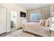Cozy bedroom with plaid wallpaper, decorative pillows, and adjacent bathroom at 16486 Florawood Pl, Monument, CO 80132
