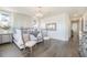 Spacious bedroom with large window, stylish light fixture, and elegant decor with wood flooring at 16486 Florawood Pl, Monument, CO 80132