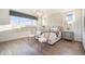 Bright bedroom with large window, stylish light fixture, and elegant decor with wood flooring at 16486 Florawood Pl, Monument, CO 80132