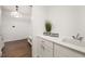 Well-lit laundry room featuring sleek white cabinetry, modern fixtures, and durable wood flooring at 16486 Florawood Pl, Monument, CO 80132