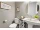 Stylish powder room with decorative wallpaper, a pedestal sink, and modern fixtures at 16486 Florawood Pl, Monument, CO 80132