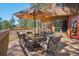 Back deck features comfortable seating, glass topped table, umbrella and a wooded view at 1332 Meadow Trl, Franktown, CO 80116