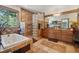 Bathroom featuring a tub, glass block shower, wooden cabinets and counter, and unique tile design at 1332 Meadow Trl, Franktown, CO 80116
