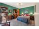 Comfortable bedroom with green walls, a full desk and bookcase, and a queen sized bed at 1332 Meadow Trl, Franktown, CO 80116