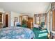 Spacious bedroom features a bed, wooden dresser with TV, a chair, and entry to an upper floor overlook at 1332 Meadow Trl, Franktown, CO 80116