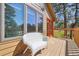Exterior view shows a wooden deck with a white chair and a orange door leading to the home's interior at 1332 Meadow Trl, Franktown, CO 80116