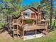 Stunning exterior elevation featuring multiple decks surrounded by mature trees, perfect for outdoor living at 1332 Meadow Trl, Franktown, CO 80116